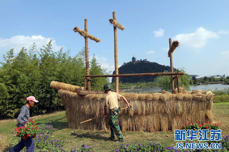 在江苏省南通市啬园,一名小女孩在观看用农作物果实制作的作品《农耕